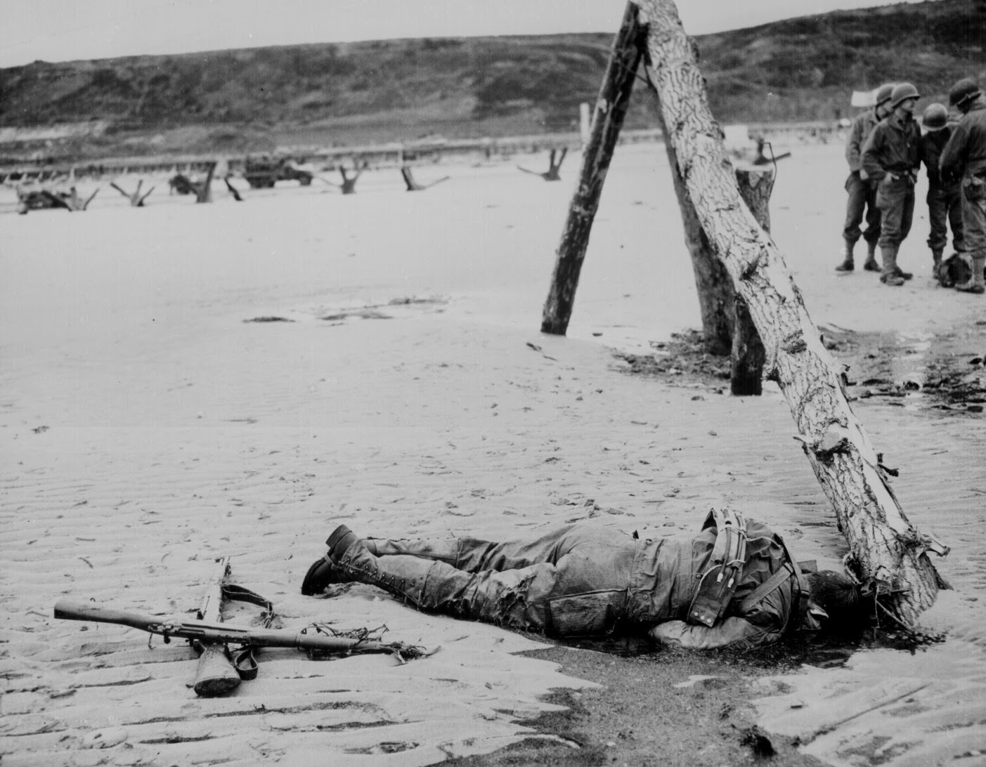 Crossed rifles in the sand placed as a tribute to this fallen soldier, 1944